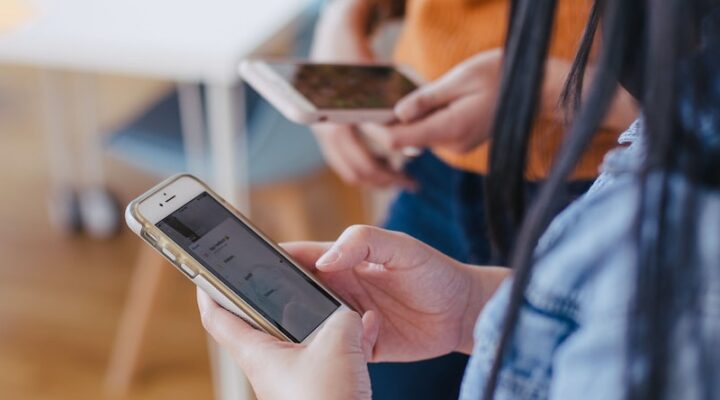 selective focus photography of woman holding phone
