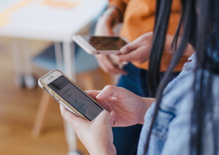 selective focus photography of woman holding phone